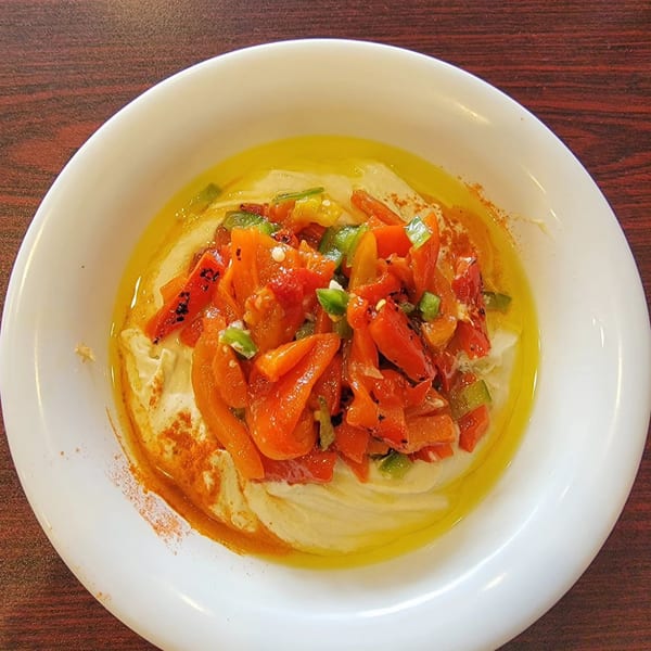 Hummus Yummy's creamy hummus topped with roasted red peppers, green chilies, olive oil, and paprika.